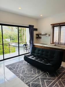 a black couch in a living room with a large window at GM Apartments 2 Bedrooms in Nathon Bay +22 photos