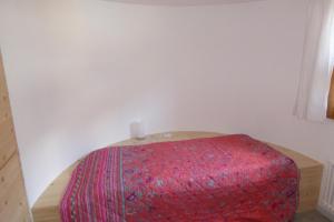 a red ottoman in a corner of a room at Apartment for 1-4 people Chasa Plazzöl in Müstair