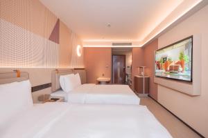 Postel nebo postele na pokoji v ubytování Orange Guangzhou Baiyun Airport Hotel + 19 fotografií