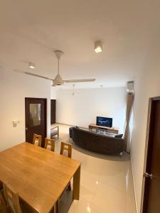 a living room with a table and a couch at Elixia 3C'S by Planet Path in Sri Jayewardenepura Kotte