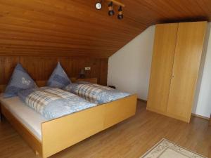 ein Schlafzimmer mit einem Bett mit blauen Kissen in der Unterkunft Ferienwohnung Dietsche in Dachsberg im Schwarzwald