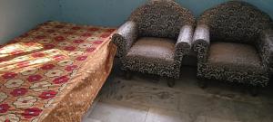 two chairs and a table in a room at Sushma Homestay in Bhauvāpār