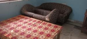 a bedroom with a chair and a bed and a table at Sushma Homestay in Bhauvāpār