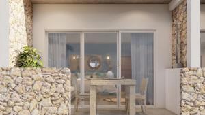 a dining room with a table and a stone wall at So KohKoon Beach Resort in Bang Rak Beach