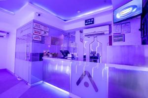 a kitchen with a counter in a room with purple lights at Astrotel Cebu in Cebu City
