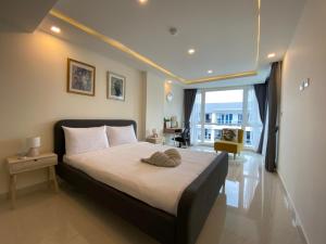 a bedroom with a large bed with a large window at Grand Avenue By MonthStayZ Thailand in Pattaya Central