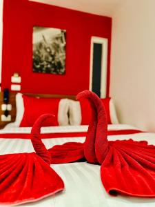 a red bedroom with two red towels on a bed at PJ Patong Resortel in Patong Beach