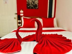 two red swans are sitting on a bed at PJ Patong Resortel in Patong Beach