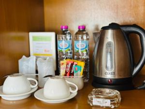 a coffee maker and cups on a table at PJ Patong Resortel in Patong Beach