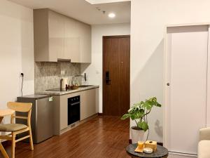 a kitchen with white cabinets and a table in a room at A Quiet Stay - Elegant in Gia Lâm Pho
