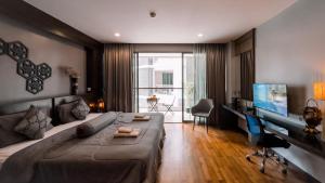 une chambre avec un grand lit et une télévision à écran plat dans l'établissement Cozy studio near Bangtao Beach, à Bang Tao Beach 17 autres photos