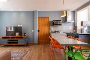 a kitchen with a table and orange chairs at Lapa Chêca Guest House in Rio de Janeiro