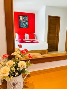 a bedroom with a bed with a red wall at PJ Patong Resortel in Patong Beach