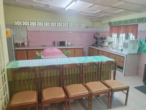 a kitchen with a table and chairs in a room at Homestay Che Mas in Jertih +4 photos