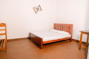 Una cama pequeña en una habitación con un letrero x en la pared en Dunitha Villa - Surrounded by Greenery, en Dikwella