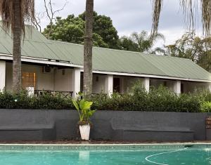 a house with a swimming pool in front of it at Georges Valley Lodge in Tzaneen