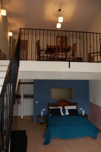 a bedroom with a blue bed and a balcony at Ca l'Estruch in Vallclara
