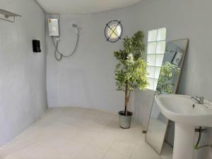 a bathroom with a sink and a toilet and a shower at บ้านดิน 2 ชั้น in Khanong Phra