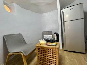 a kitchen with a chair and a refrigerator at บ้านดิน 2 ชั้น in Khanong Phra