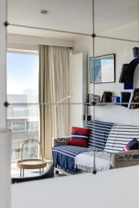 Un dormitorio con una cama y una silla y una ventana. en Les Voiliers 21, en Sint-Idesbald