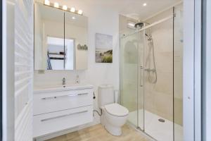 Un baño blanco con inodoro y ducha. en Les Voiliers 21, en Sint-Idesbald 6 fotos más