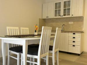 メジュゴリエにあるMedjugorje Apartmentのキッチン(白いテーブル、椅子4脚付)