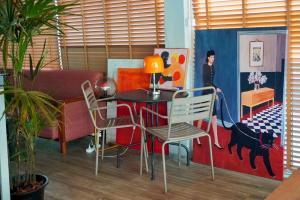 a living room with a table and chairs in a room at BW Thai Art Style Hotel in Bangkok