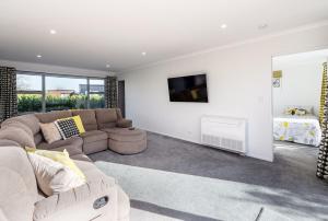 a living room with a couch and a tv at 18 on Burgundy in Martinborough 