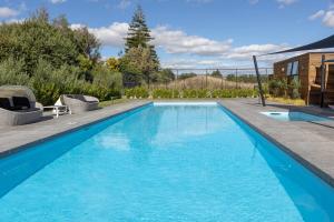 a swimming pool with blue water in a yard at 18 on Burgundy in Martinborough 
