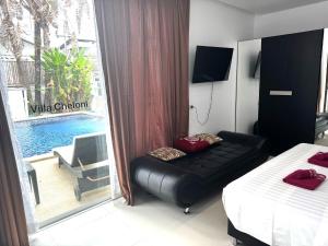 a bedroom with a black leather couch in front of a window at VILLA CHELONI 2 BEDROOMS in Kamala Beach +34 photos
