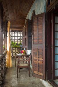 a room with a table and a wooden door at Emerson Spice in Zanzibar City +16 photos