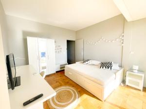 une chambre blanche avec un lit et un bureau dans l'établissement Appartement Promenade des Anglais, à Nice 3 autres photos