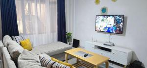 a living room with a couch and a tv at Delight stays in Ongata Rongai 