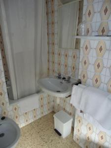 y baño con lavabo y espejo. en Residència Restaurant Indalo en Andorra la Vella