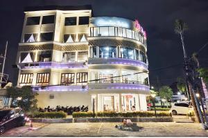 a tall building with people sitting in front of it at YUTAKA INN Sriwijaya Tegalsari Surabaya in Surabaya