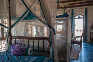 a bedroom with a bed with a canopy at Emerson Spice in Zanzibar City