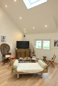 a living room with a couch and a tv at Le photo studio in Tremblois-lès-Rocroi