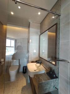 Un baño con lavabo, inodoro y espejo. en Mandala Coast Chambay Bình Thuận, en Ấp Nhơn Long 1 foto más