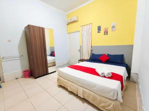 a bedroom with a bed with two towels on it at YUTAKA INN Sriwijaya Tegalsari Surabaya in Surabaya