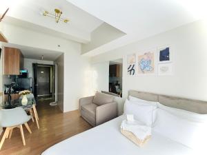 カガヤン・デ・オロにある25F Condo at The Loop Tower Limketkai Center CDOのベッドルーム(白いベッド1台付)、リビングルームが備わります。