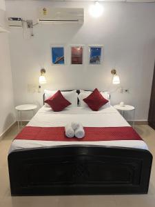 a bedroom with a large bed with red pillows at Peaceful studio home in South Goa in Salcete