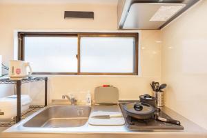 una piccola cucina con un lavandino e una finestra di 120Tb 楓屋2F 楓屋アネックス 67m貸切 三田線志村坂上駅徒歩10分東京タワー直通キッズスペースリノベ a Tokyo Altre 37 foto