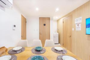 una sala da pranzo con tavolo in legno e sedie bianche di 120Tb 楓屋2F 楓屋アネックス 67m貸切 三田線志村坂上駅徒歩10分東京タワー直通キッズスペースリノベ a Tokyo