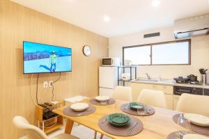 una sala da pranzo con un tavolo e una TV a parete di 120Tb 楓屋2F 楓屋アネックス 67m貸切 三田線志村坂上駅徒歩10分東京タワー直通キッズスペースリノベ a Tokyo