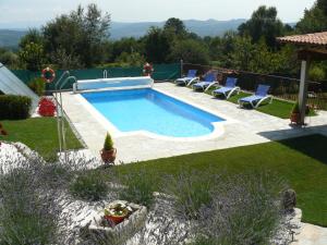 a swimming pool in a yard with chairs around it at Hotel A Palleira in Allariz