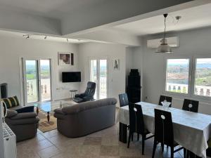 a living room with a table and chairs and a couch at Olympus View in Palaión Keramídion