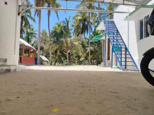 an empty playground with palm trees and a blue staircase at Coco farm in Pāmban