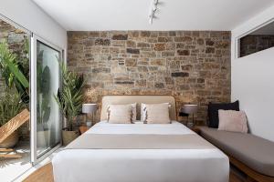 カラファティスにあるVilla Yaseminのベッドとレンガの壁がある寝室 +80枚の写真