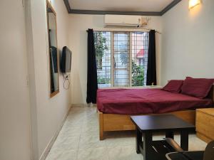 a small room with a bed and a window at Anusattva Vatika in Bengaluru