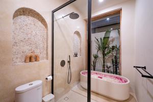 a bathroom with a shower and a bath tub at Villa Samara Pererenan in Tumbak Bayuh
